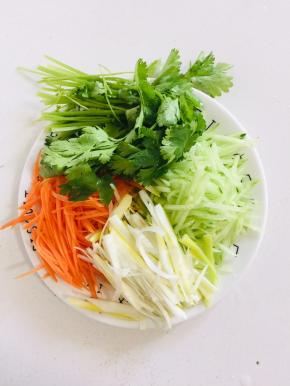 胡萝卜削皮切成丝，黄瓜削皮切成丝，葱切成丝，香菜洗净备用！