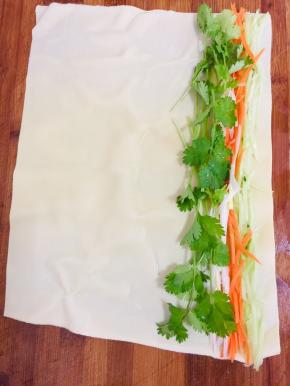 千张平铺在案板上，均匀的放入胡萝卜丝，黄瓜丝，葱丝，香菜。