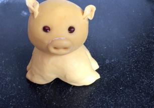 用黄面团做一只小金猪，用红豆做小金猪的眼睛