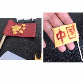 先用红面团做一面国旗，用黄面团做出五角星，沾湿贴在红旗上，再做一面黄旗写上自己想表达的意思