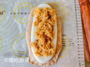 在麻薯上铺一层葡萄干，再铺一层肉松。