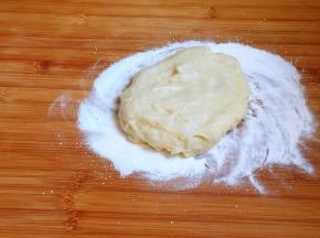 案板上撒一些手粉，将糯米团稍加揉搓。