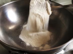 第一步，先炒手粉，将150克过好晒的糯米粉加入锅中，锅要保持无油无水的状态。