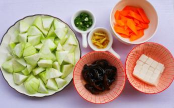 丝瓜洗净去皮切滚刀块，木耳温水泡发，豆腐切小块淡盐水浸泡，胡萝卜切菱形，姜切丝，葱切葱花。