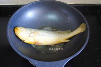 热锅，锅内倒入适量的油，放入敷了薄淀粉的黄花鱼，中小火慢煎。