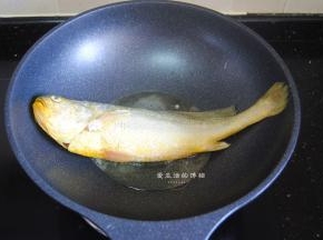 热锅，锅内倒入适量的油，放入敷了薄淀粉的黄花鱼，中小火慢煎。