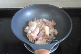 倒入沥干水的鸡肉，转大火，把鸡肉快速翻炒开来。