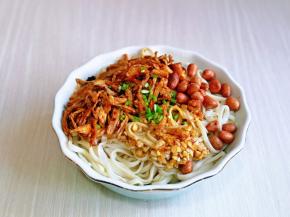 过水的面条捞出淋干水分，放入面碗中，淋上调味料，拌好的酸辣鸡丝。熟的花生米，撒上葱花，拌均匀即可食用。