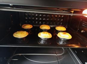 烤至的蛋挞个个鼓起了小肚肚，烤至表面出焦圈即可。