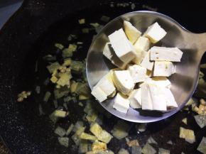 锅中加入三汤碗（一个人量的汤碗），包括浸泡黄花菜的水，倒入胡辣汤内的菜包，加入豆腐丁。