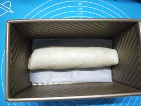 卷好的面团，放入吐司盒中，如果担心蛋糕糊会从底部孔中漏出，可以垫张油纸，放温度湿润处进行二发