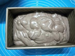 将翻拌均匀的蛋糕糊慢慢倒入吐司模具中