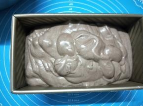 将翻拌均匀的蛋糕糊慢慢倒入吐司模具中