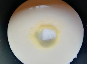 加入纯牛奶和细砂糖，开最小火加热，搅动至细砂糖完全融化关火。