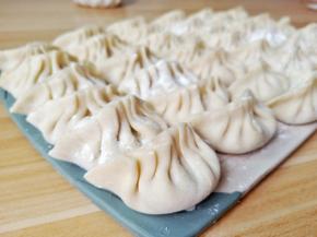 拿一张饺子皮加上肉馅包好。