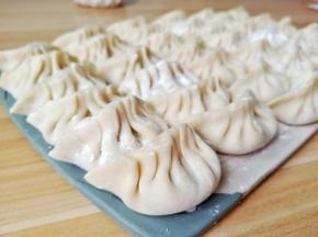 拿一张饺子皮加上肉馅包好。