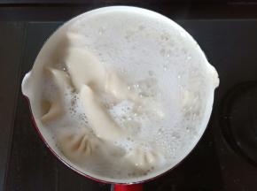 将锅里的水烧开下入饺子，开大火沸腾后加入一勺冷水，再沸腾再加入冷水，再次沸腾后即可关火入盘【如果是素馅可以只加一次冷水】