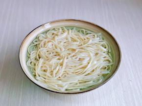 煮好的面捞出放入器具中，过冷水，再淋干水分备用。