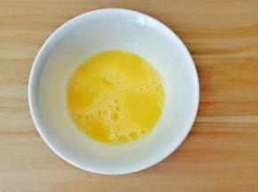 鸡蛋磕入碗里打散。