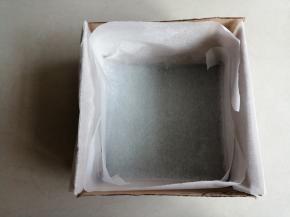首先在18*18CM的正方形模具底部铺一张油纸，并在四周插上纸板，有利于蛋糕的爬升