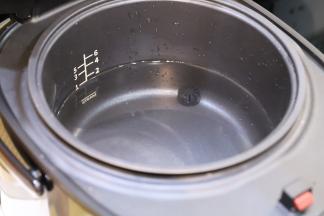 水倒入脱糖电饭煲的三脚釜内，大概一刻水。