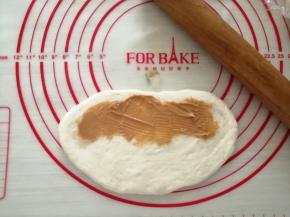 把小面团擀成椭圆形，一侧抹上花生酱