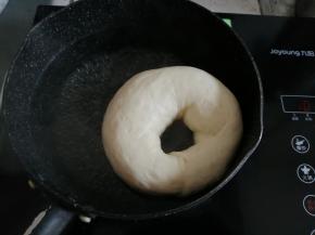 锅里加水和糖，煮至沸腾后转小火，把发酵好的面包胚放入，两面各煮20-30秒