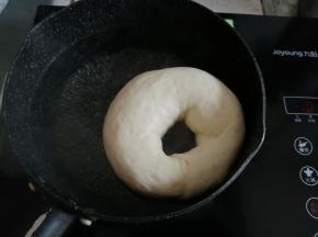 锅里加水和糖，煮至沸腾后转小火，把发酵好的面包胚放入，两面各煮20-30秒