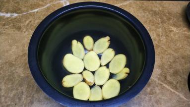 切片的姜片放入电饭煲底铺好