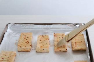 烤盘铺上锡纸，摆入豆干，表面刷一层油。