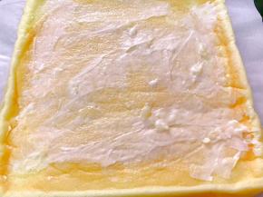 出炉震出热气，倒扣在铺有油纸的烤架上，趁热撕下蛋糕体的油纸，抹上沙拉酱