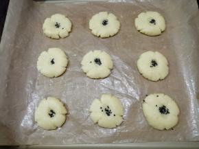 用手掌轻轻把小圆面团压扁，中间按个洞，撒上黑芝麻，如果你想成品颜色亮色一些，可以在表面刷上一层蛋液。放入已经预热到上火180度，下火160度的烤箱，烘烤15分钟左右（实际烘烤温度要根据自家烤箱脾气而定）