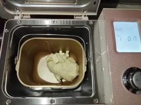 在第一次和面结束后，加入切成小块的黄油，继续选择和面17分钟，不同型号的面包机和面时间会有所不同，和至能拉出手套膜为好。把和好的面团压平，用保鲜袋装好，放入冰箱冷冻层冷冻1个小时