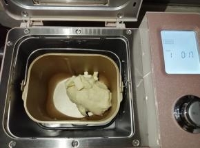 在第一次和面结束后，加入切成小块的黄油，继续选择和面17分钟，不同型号的面包机和面时间会有所不同，和至能拉出手套膜为好。把和好的面团压平，用保鲜袋装好，放入冰箱冷冻层冷冻1个小时