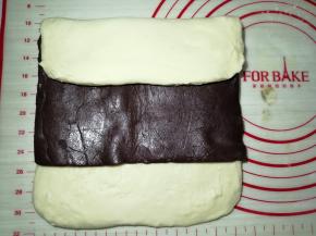 上面的面团往下折，盖住一半的豆沙馅