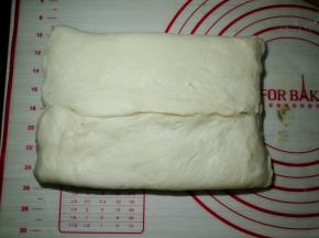 下面的面团往上折，把面团接缝处捏紧，两边也捏紧，不露出豆沙馅。