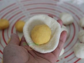 白面团用擀面杖擀薄，放入南瓜面团包裹，揉搓光滑。