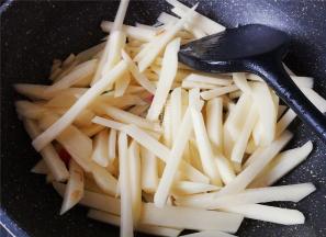 把土豆条捞起沥干，倒入锅中翻炒下，炒制微微变色。