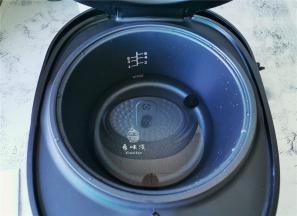 把电饭煲的内胆装入适量清水，把甑子放入，水千万不要没过甑子底部。