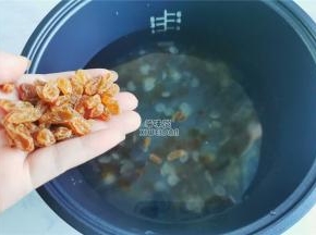 把泡发的水倒掉，挑出杂质，倒入电饭煲内胆中，倒入适量清水，放入葡萄干。