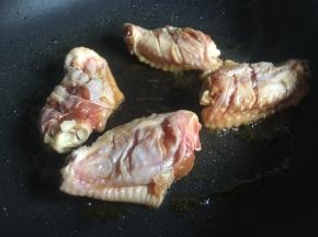 锅中倒少许食用油烧热，将鸡翅上的水分要擦干防止溅油，再依次排放锅中改小火慢煎；