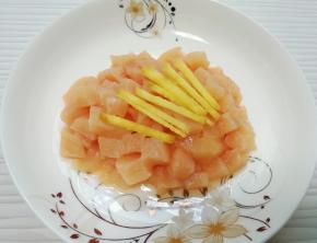 鸡脯肉洗干净切成丁，生姜片切成丝，放在一起。