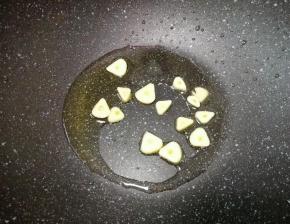 锅底留余油，下入大蒜炒香。