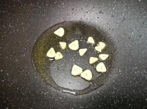 锅底留余油，下入大蒜炒香。