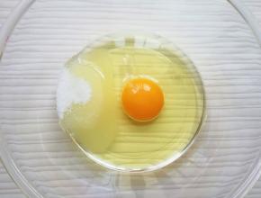 将鸡蛋打入盆里，加入玉米油和细砂糖。