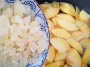 将黄桃块放入电饭锅里面，加入黄冰糖。