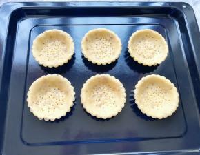 将做好的挞皮码在烤盘里。