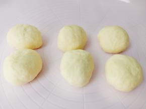 面团放在垫子上，挤出面团里面的空气，分成6份，揉圆盖上保鲜膜放在室温下醒发15分钟。