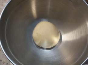 大约13-15分钟的时候，暂停程序，取出一半的面团，收拢光滑后放入打蛋盆内，盖上保鲜膜进行一次发酵。
