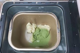 另一半面团再次切成小块放入面包桶，同时倒入抹茶粉，以及5g左右的牛奶，继续启动程序。